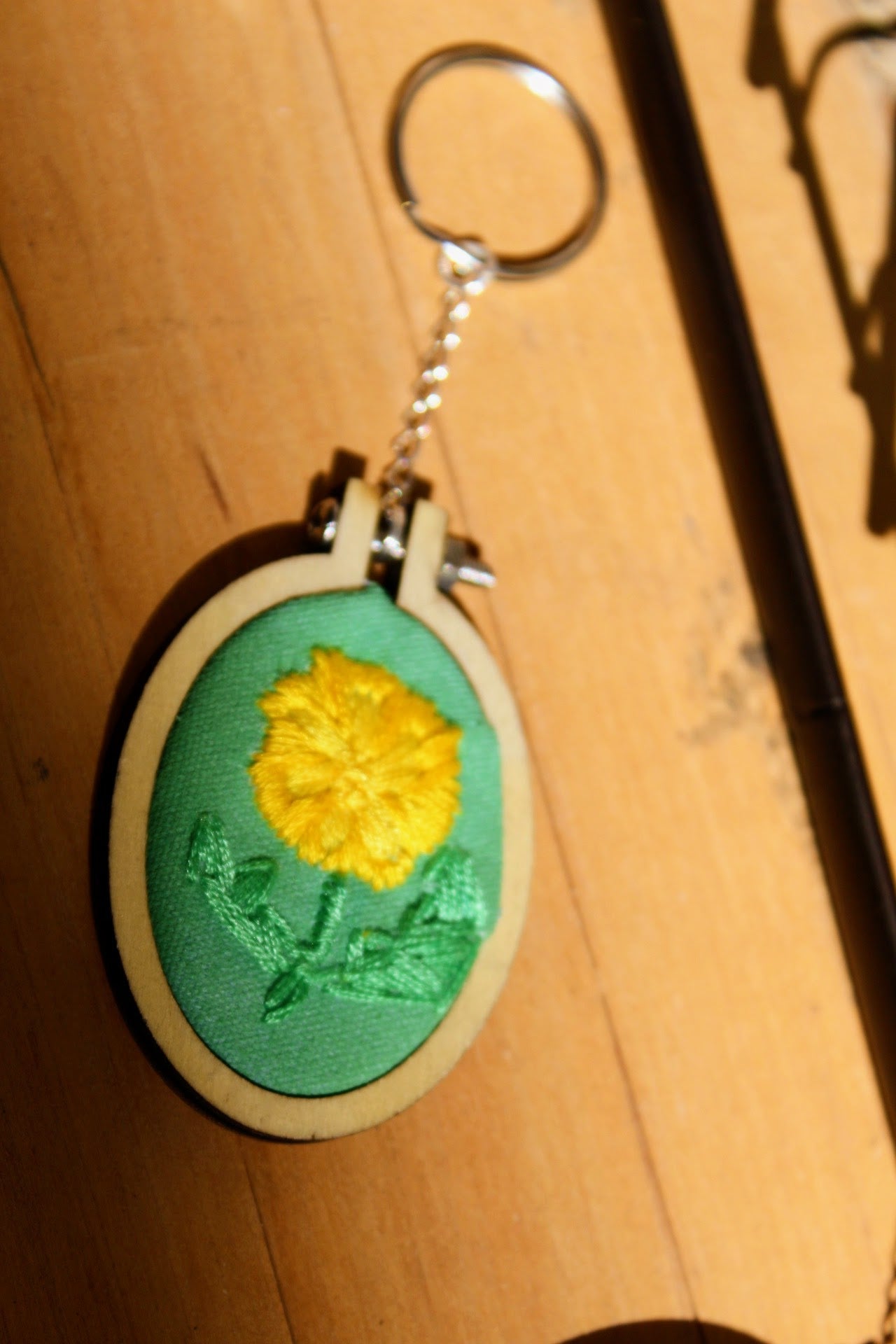Keychain with yellow flower design on a wooden surface